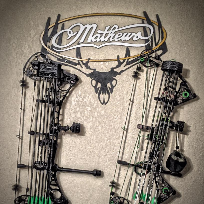 Two Mathews archery bows displayed against a neutral background with the Mathews Raxx hanger